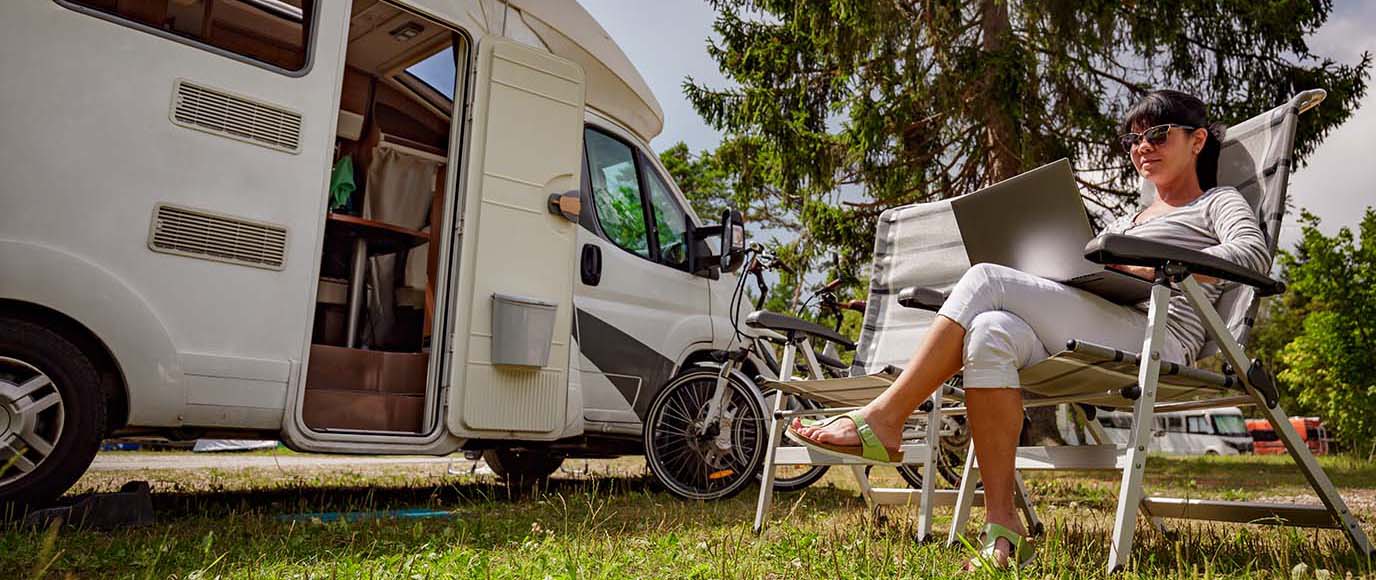 Motorhome owner reading their digital RV inspection report on a laptop while camping